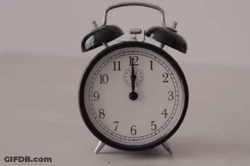 A Black And White Alarm Clock Shows That It Is Almost 5:00 GIF