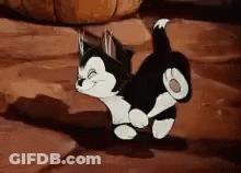 A Black And White Cartoon Cat Is Walking On A Rocky Surface . GIF