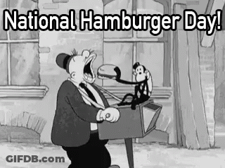 A Black And White Cartoon Of A Man Eating A Hamburger With A Monkey Sitting On A Lamp Post . GIF