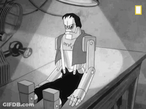 A Black And White Cartoon Of Frankenstein Sitting On Top Of A Table . GIF
