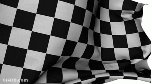 A Black And White Checkered Flag Is Being Blown In The Wind GIF