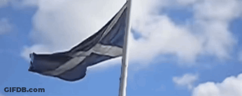 A Black And White Flag Is Waving In The Wind Against A Blue Sky With Clouds GIF