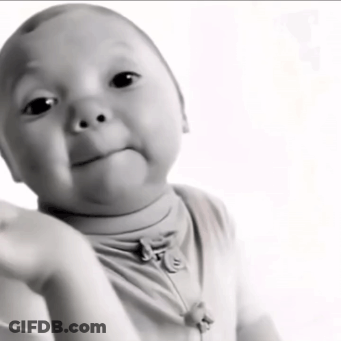 A Black And White Photo Of A Baby With A Necklace Around His Neck GIF