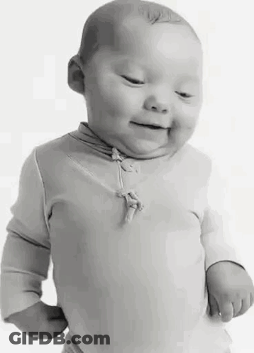 A Black And White Photo Of A Baby With Down Syndrome Smiling . GIF