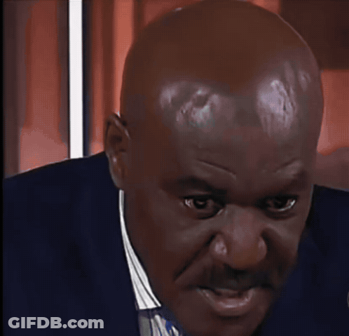 A Black And White Photo Of A Bald Man Wearing A Black Suit And Tie GIF