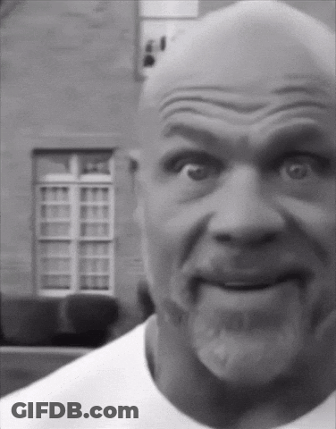 A Black And White Photo Of A Bald Man With A Beard Making A Funny Face GIF
