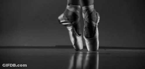 A Black And White Photo Of A Ballerina 'S Feet In Pointe Shoes Jumping In The Air . GIF