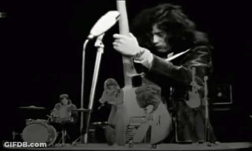 A Black And White Photo Of A Band Playing Instruments On A Stage GIF