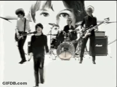 A Black And White Photo Of A Band Playing Instruments On A Stage . GIF