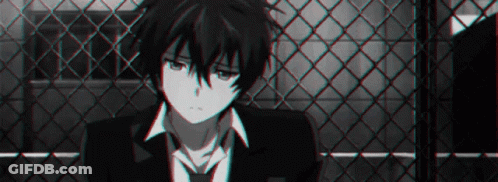 A Black And White Photo Of A Boy In A Suit And Tie Sitting In Front Of A Chain Link Fence . GIF