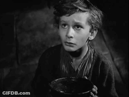 A Black And White Photo Of A Boy With The Words I Want Some More Above Him GIF
