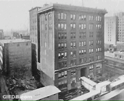 A Black And White Photo Of A Building With A Lot Of Windows GIF