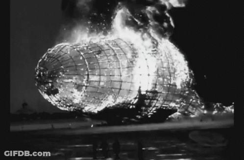A Black And White Photo Of A Burning Airship With Flames Coming Out Of It GIF