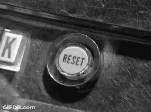 A Black And White Photo Of A Button That Says Reset On It . GIF