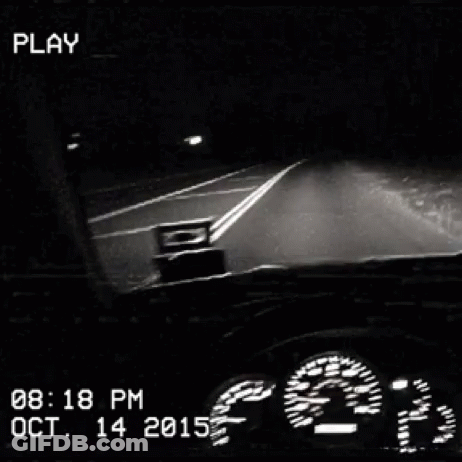 A Black And White Photo Of A Car Driving Down A Highway At Night GIF