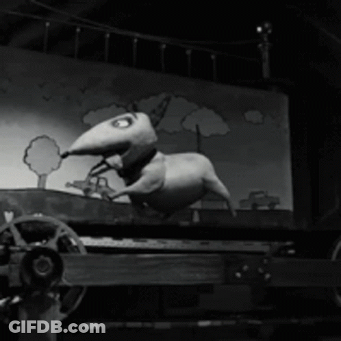 A Black And White Photo Of A Cartoon Dog On A Cart GIF