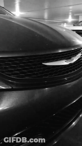 A Black And White Photo Of A Chrysler Car In A Parking Garage GIF