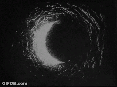 A Black And White Photo Of A Circle In The Dark . GIF
