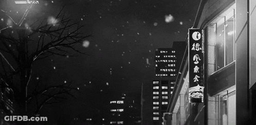 A Black And White Photo Of A City Street With Chinese Writing On A Sign GIF