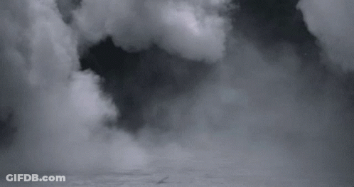 A Black And White Photo Of A Cloudy Sky With A Plane Flying Through It . GIF