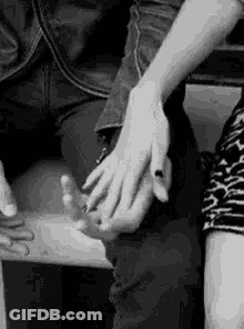 A Black And White Photo Of A Couple Holding Hands . GIF