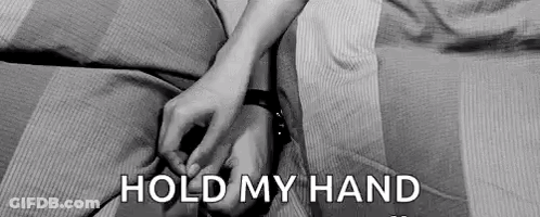 A Black And White Photo Of A Couple Holding Hands On A Bed With The Words `` Hold My Hand '' . GIF