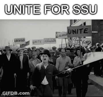 A Black And White Photo Of A Crowd Of People Marching Down A Street Holding Signs . GIF