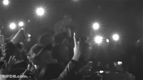 A Black And White Photo Of A Crowd Taking Pictures With Their Cell Phones GIF