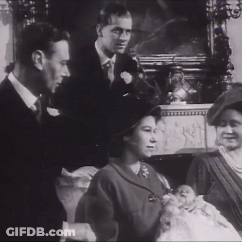 A Black And White Photo Of A Family With A Baby In The Middle GIF