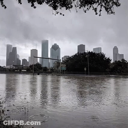 A Black And White Photo Of A Flooded City With The Skyline In The Background . GIF