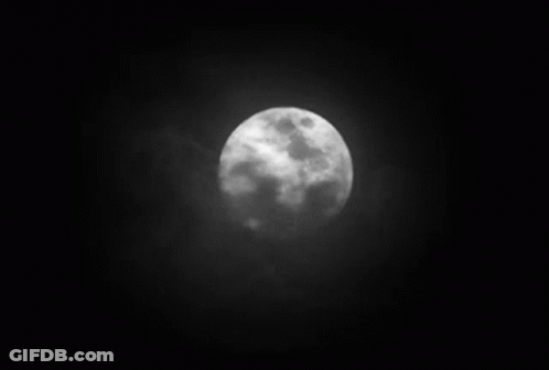 A Black And White Photo Of A Full Moon In The Night Sky GIF