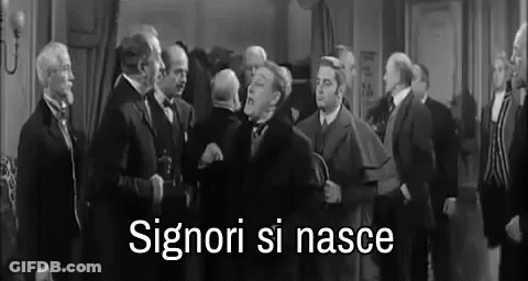 A Black And White Photo Of A Group Of Men Standing In A Room With The Words Signori Si Nasce Written In White . GIF