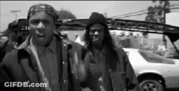 A Black And White Photo Of A Group Of Men Standing Next To A Car . GIF