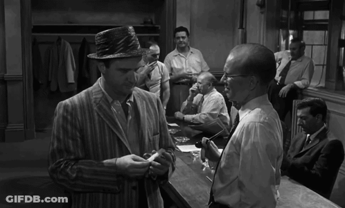 A Black And White Photo Of A Group Of Men Talking GIF