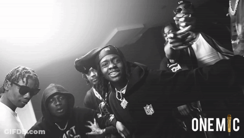 A Black And White Photo Of A Group Of Men With One Wearing A Nfl Hoodie GIF