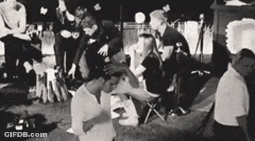 A Black And White Photo Of A Group Of People Sitting In A Circle . GIF