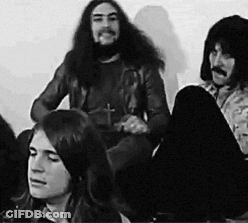 A Black And White Photo Of A Group Of People Sitting On The Floor In A Room . GIF