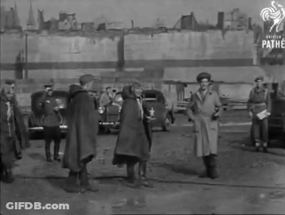 A Black And White Photo Of A Group Of People Standing In A Parking Lot With Pathe Written On The Bottom GIF