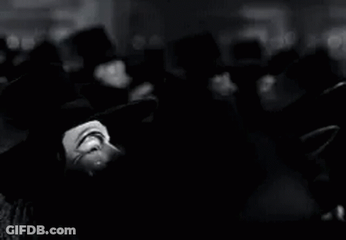 A Black And White Photo Of A Group Of People Wearing Anonymous Masks . GIF