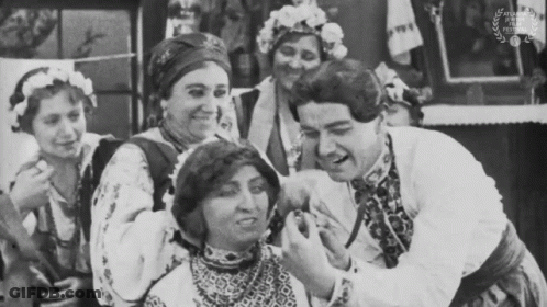 A Black And White Photo Of A Group Of People With A Laurel Wreath In The Corner GIF