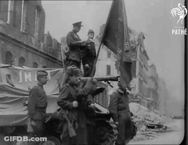 A Black And White Photo Of A Group Of Soldiers Holding A Flag GIF