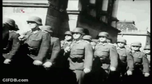 A Black And White Photo Of A Group Of Soldiers Marching In A Parade GIF