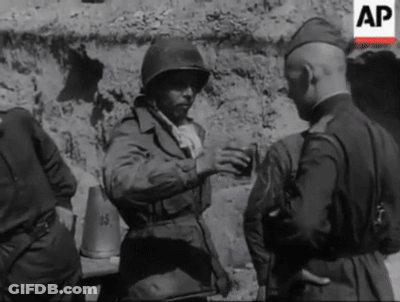 A Black And White Photo Of A Group Of Soldiers Talking . GIF