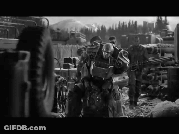 A Black And White Photo Of A Group Of Soldiers With A Robot In The Middle GIF