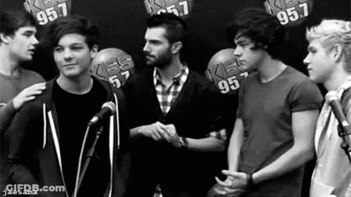 A Black And White Photo Of A Group Of Young Men Shaking Hands . GIF