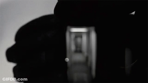 A Black And White Photo Of A Hallway With A Shadow Of A Person GIF