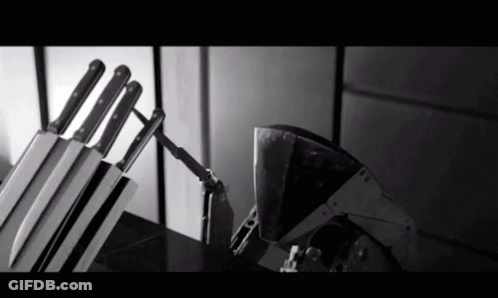 A Black And White Photo Of A Knife Block With Knives In It GIF