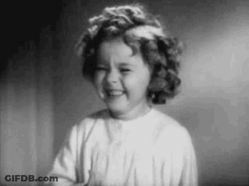 A Black And White Photo Of A Little Girl Laughing . GIF