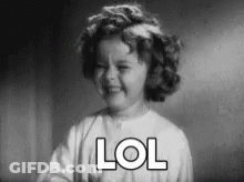 A Black And White Photo Of A Little Girl Laughing With The Word Lol Written On Her Face . GIF