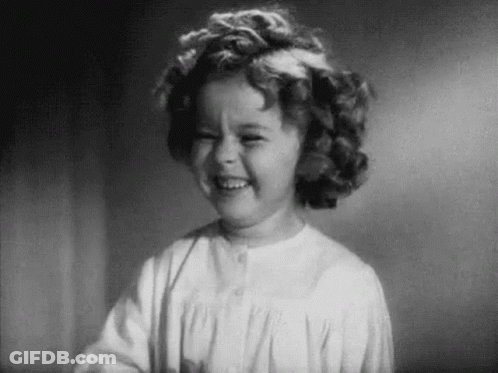 A Black And White Photo Of A Little Girl Smiling . GIF